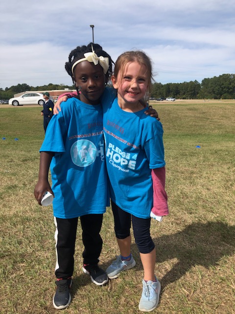 Two little girls that are best friends at a race.