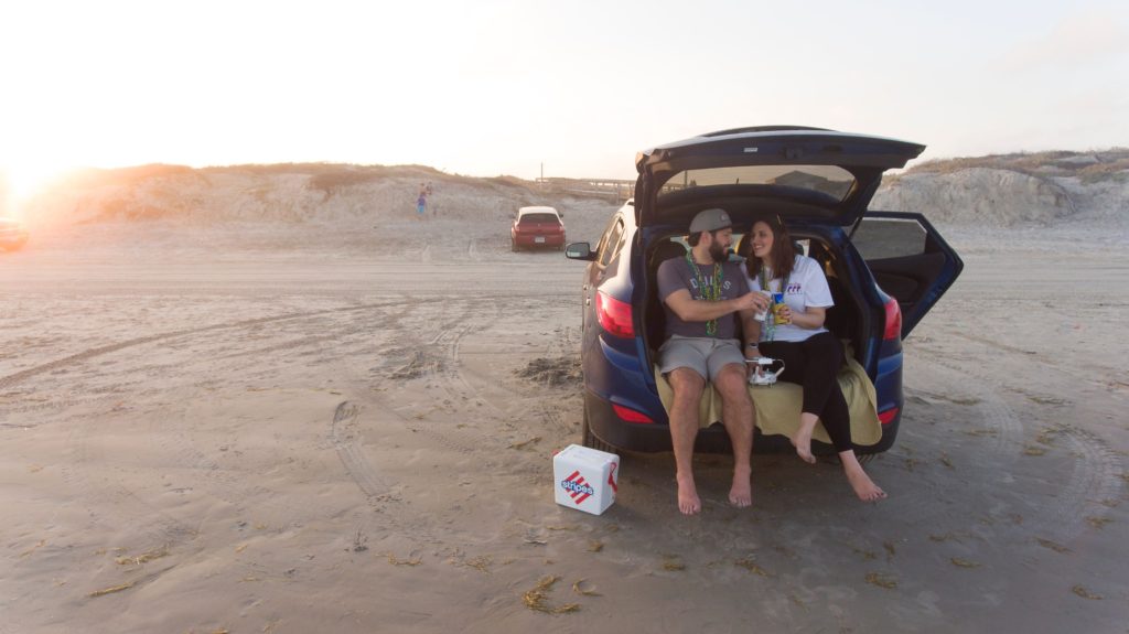 Couple having a picnic in the back of their SUV as a date night idea for an easy way to picnic.