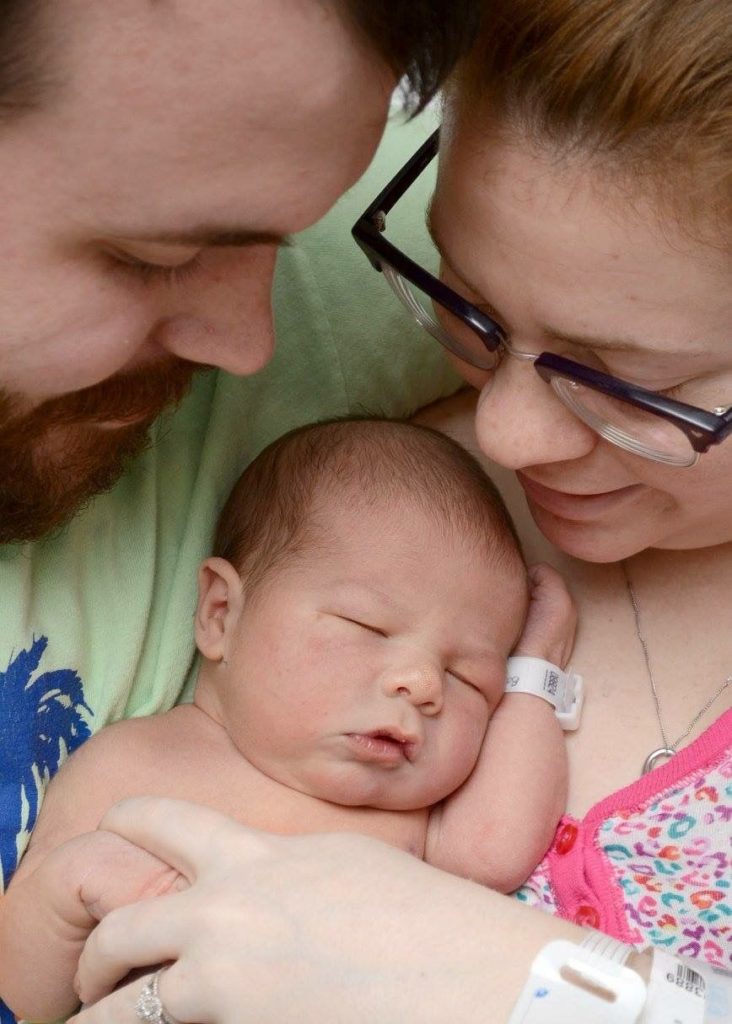 Young couple holding new born baby showing love to my children.