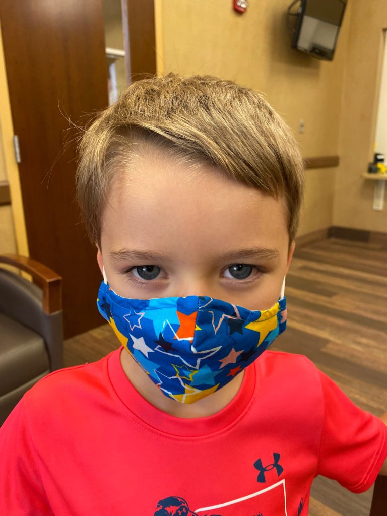 Close up of little boy wearing a blue star mask.