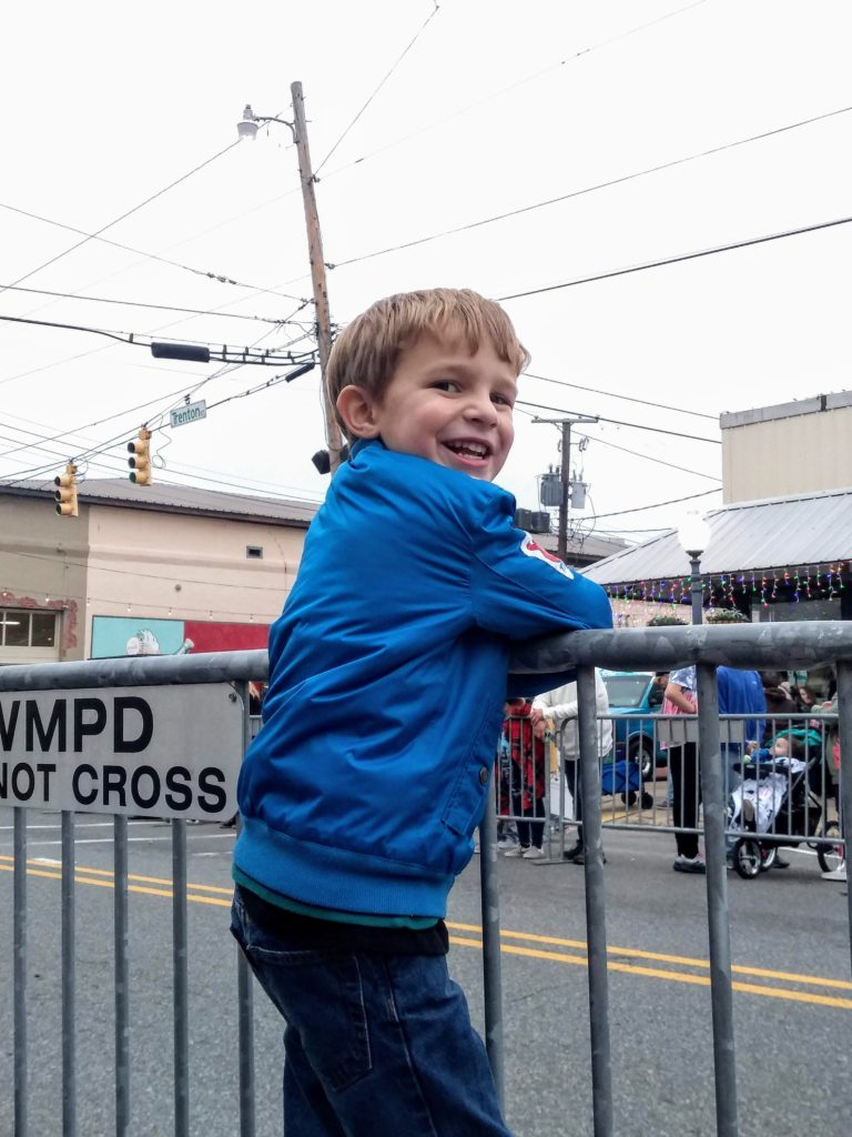 child with autism on police barrier waiting on parade
