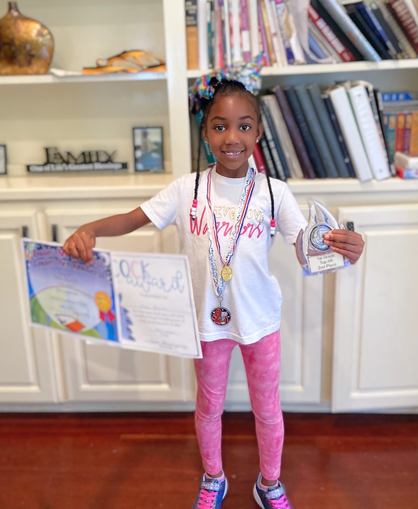 girl holding awards